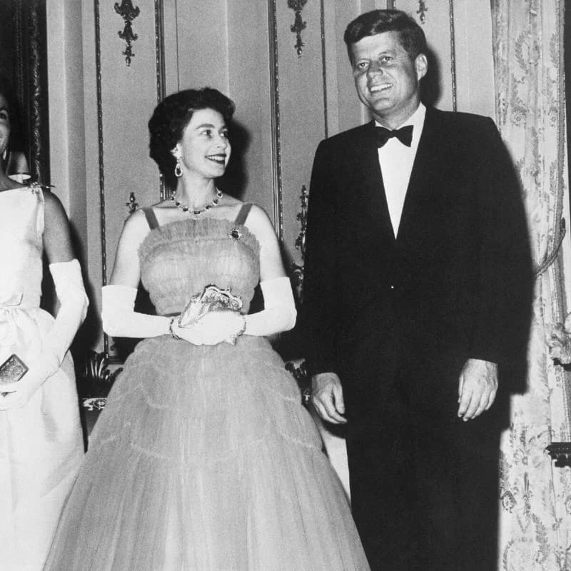 Queen Elizabeth smiles at President John F. Kennedy during a state dinner at Buckingham Palace.